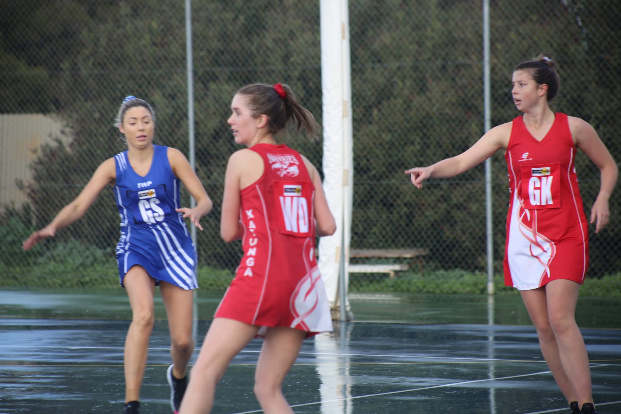 Slippery conditions ... Sarah Weideman (right) directs Grace Tyack where to pass the ball on a wet court. 
