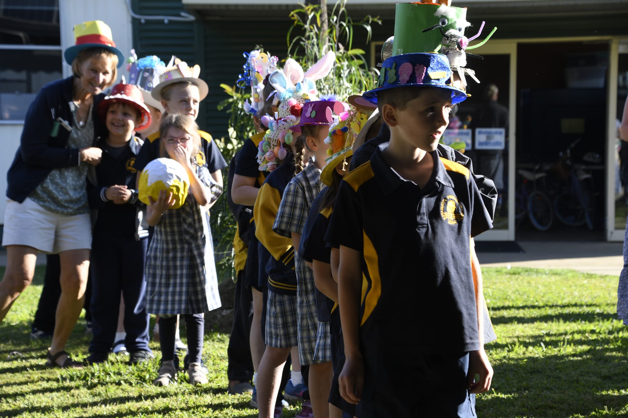 Colourful class ... The junior school group sits patiently waiting for its turn to parade their hats to the crowd. 
