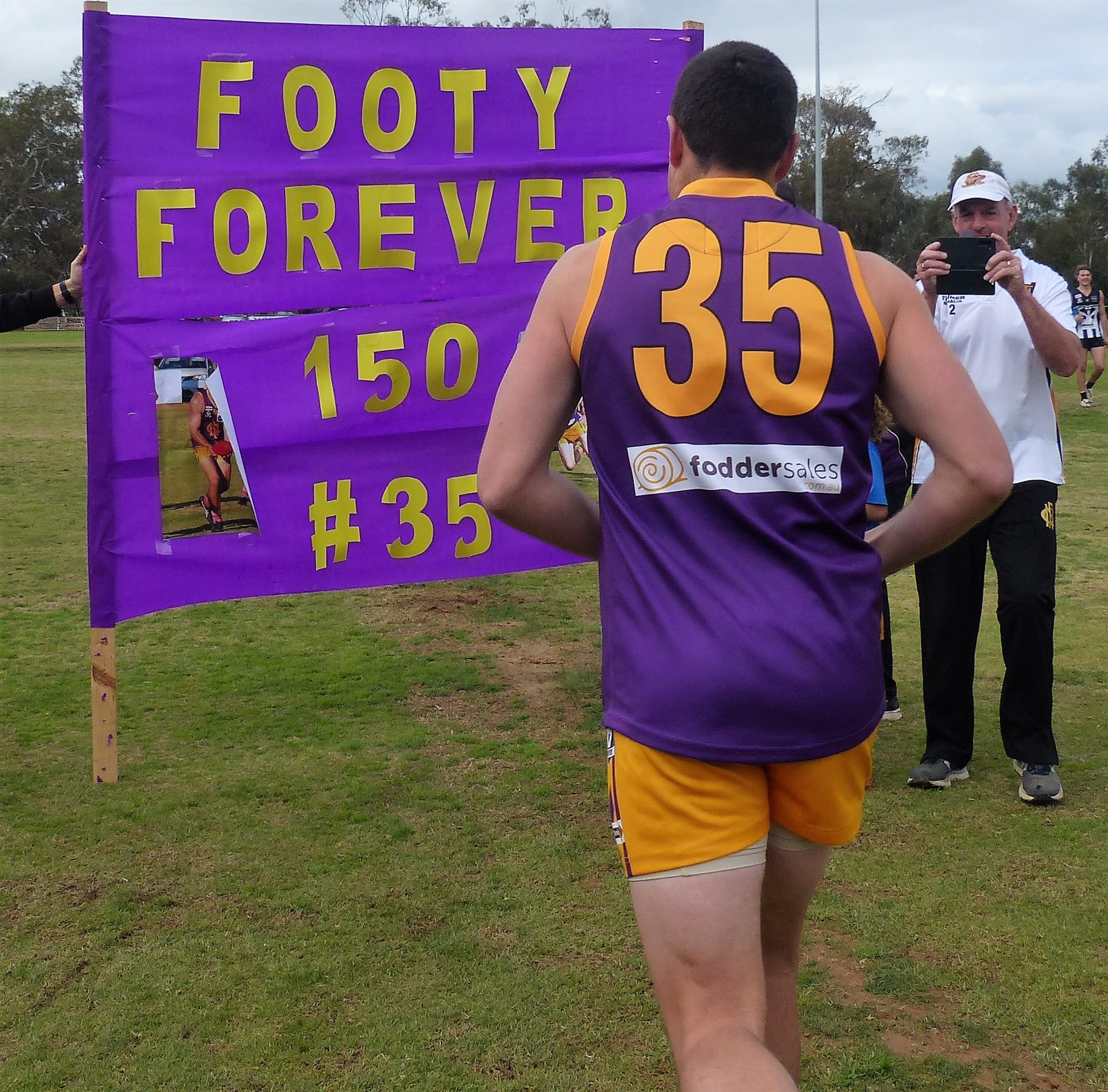 Footy forever ... Mal Barnes runs through a banner to celebrate his 150th game for Nathalia. 