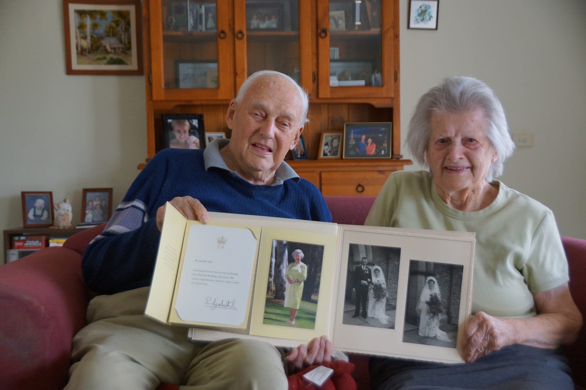 Happy together ... Les and Amy Hall reminisce over their wedding photos, and their anniversary card from Her Majesty, Queen Elizabeth.