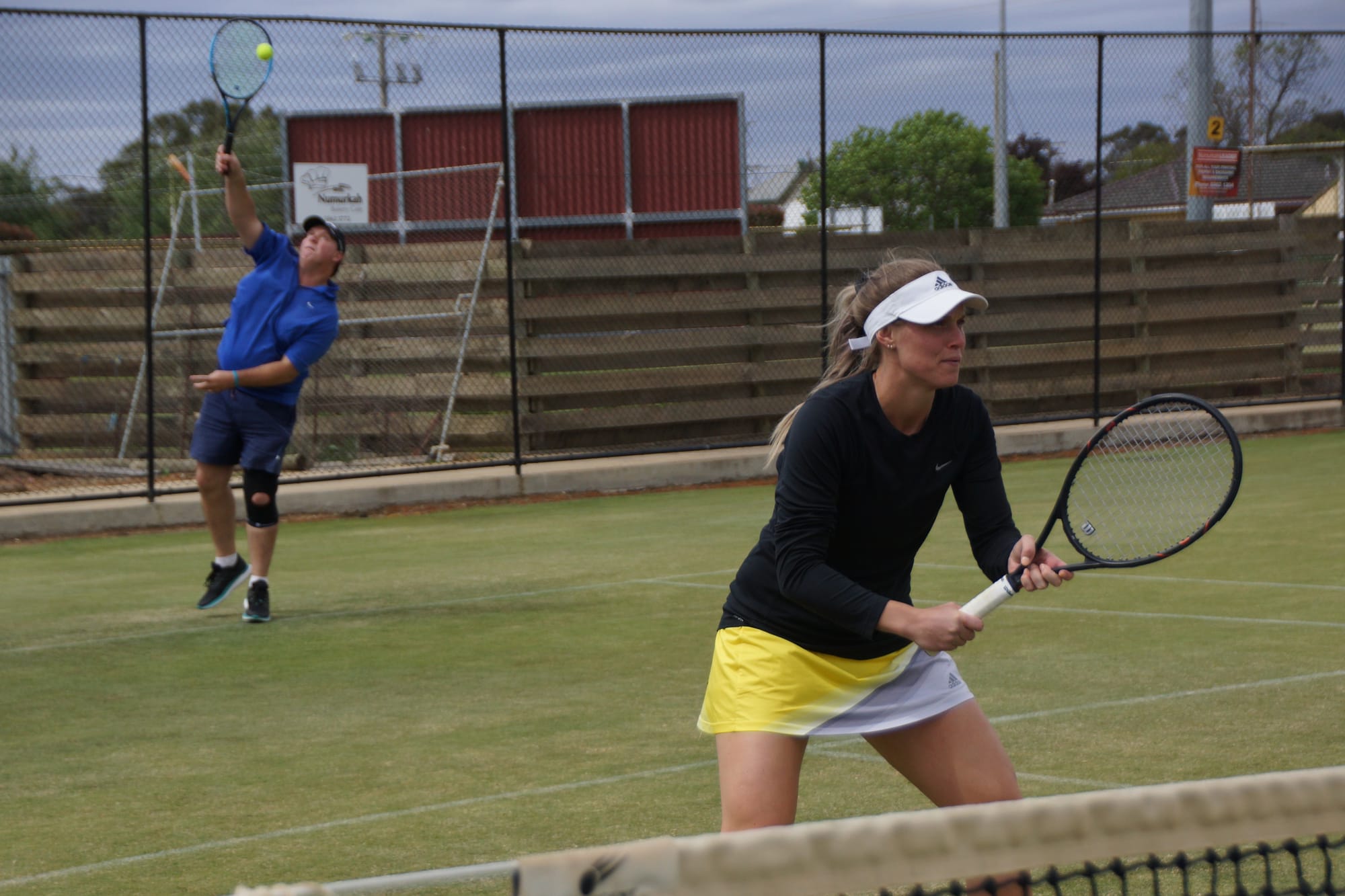 Ready, set ... Caitlyn Price makes position on the net as Matt Cason dishes up a big serve.