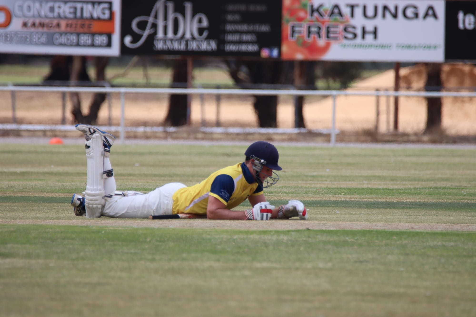 Down and out … Katandra’s Ben Clurey lies flat on the pitch after being run out.