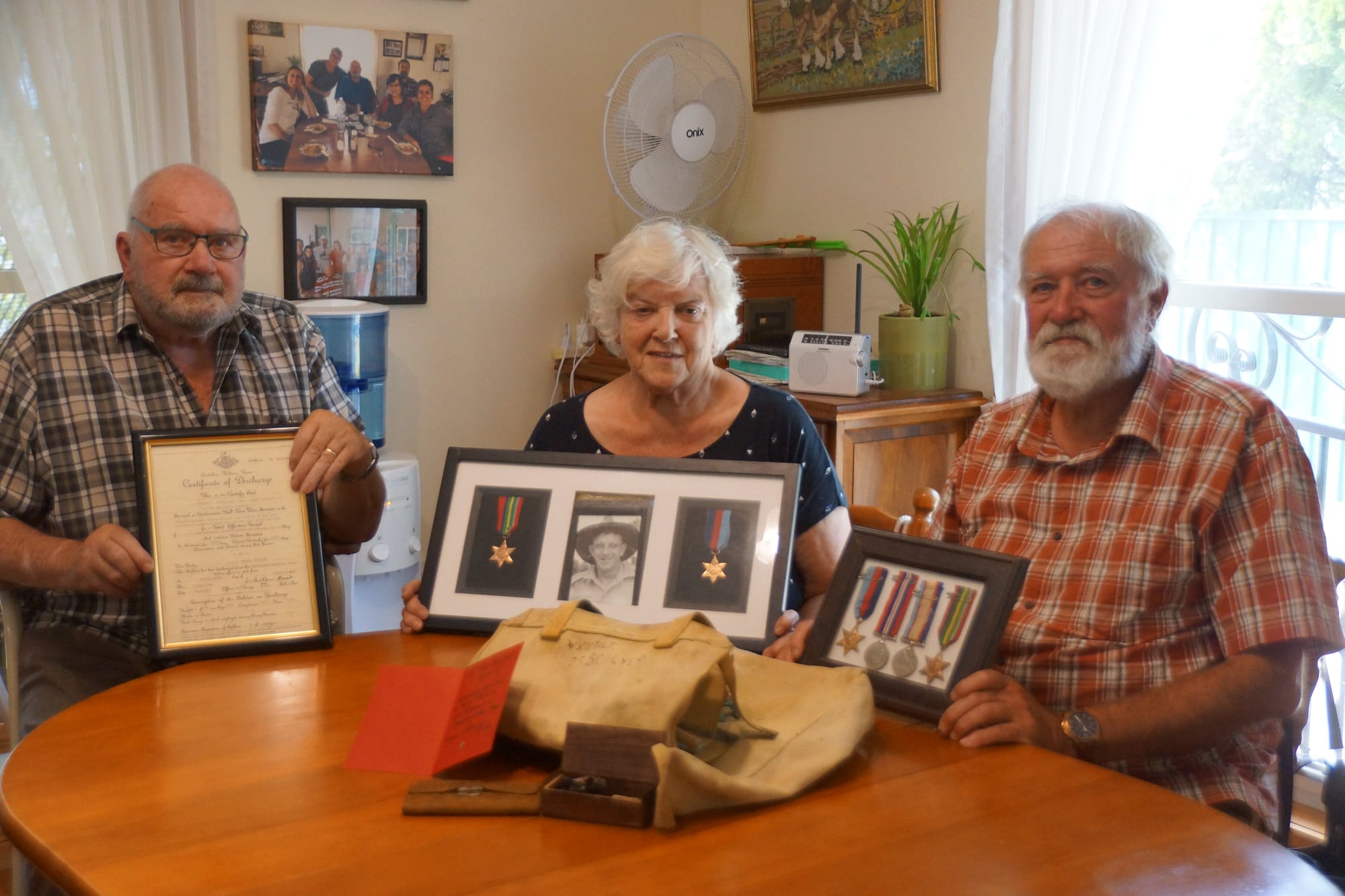 Unexpected gift ... Bob Scolyer, Cheryl Williams and Kevin Scolyer with their father’s old kit bag and other mementoes from his war time service. 