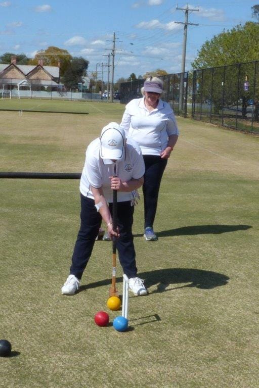 Tough shot ... Numurkah Blue pennant player Laurus Hinchcliffe playing a difficult hoop shot, watched closely by doubles partner Rhonda Geddes.