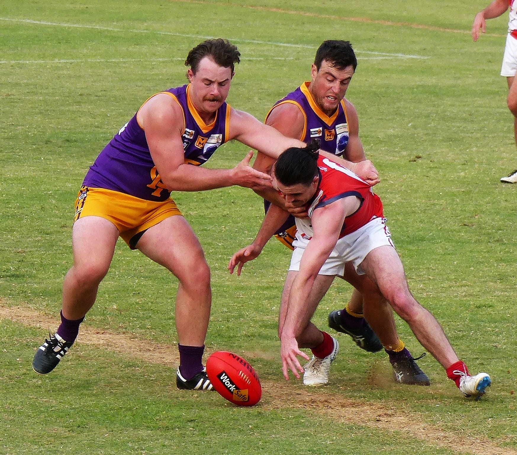 Fighting for it ... Jared Laffy (left) and Mal Barnes hunt the ball as they swarm a Congupna player. 


