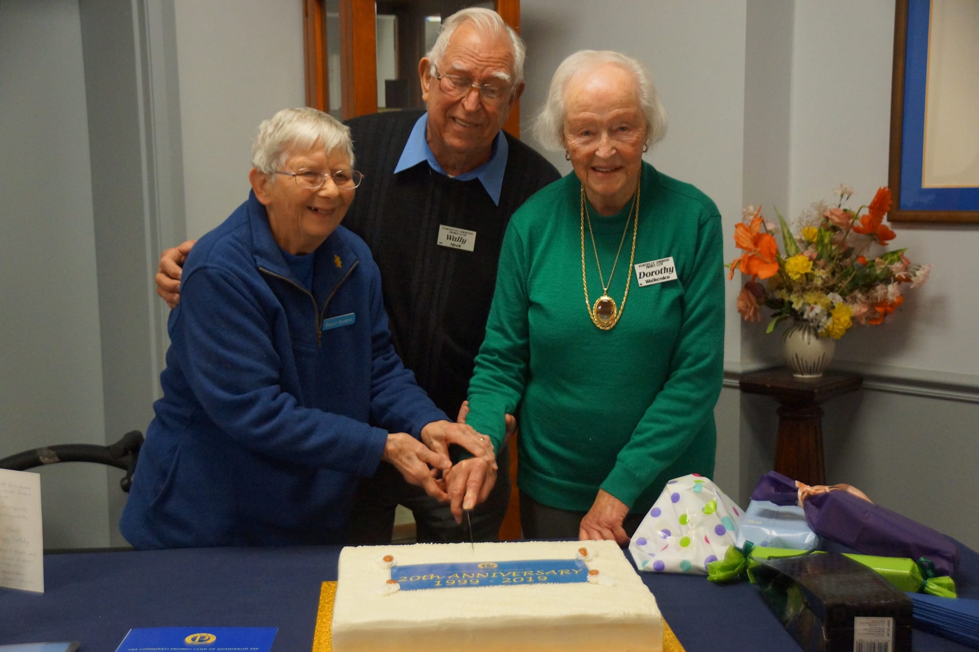 Happy birthday ... Foundation member Sally Bugeya cuts the cake with the help of Wally Meek and Dorothy Walkerden.