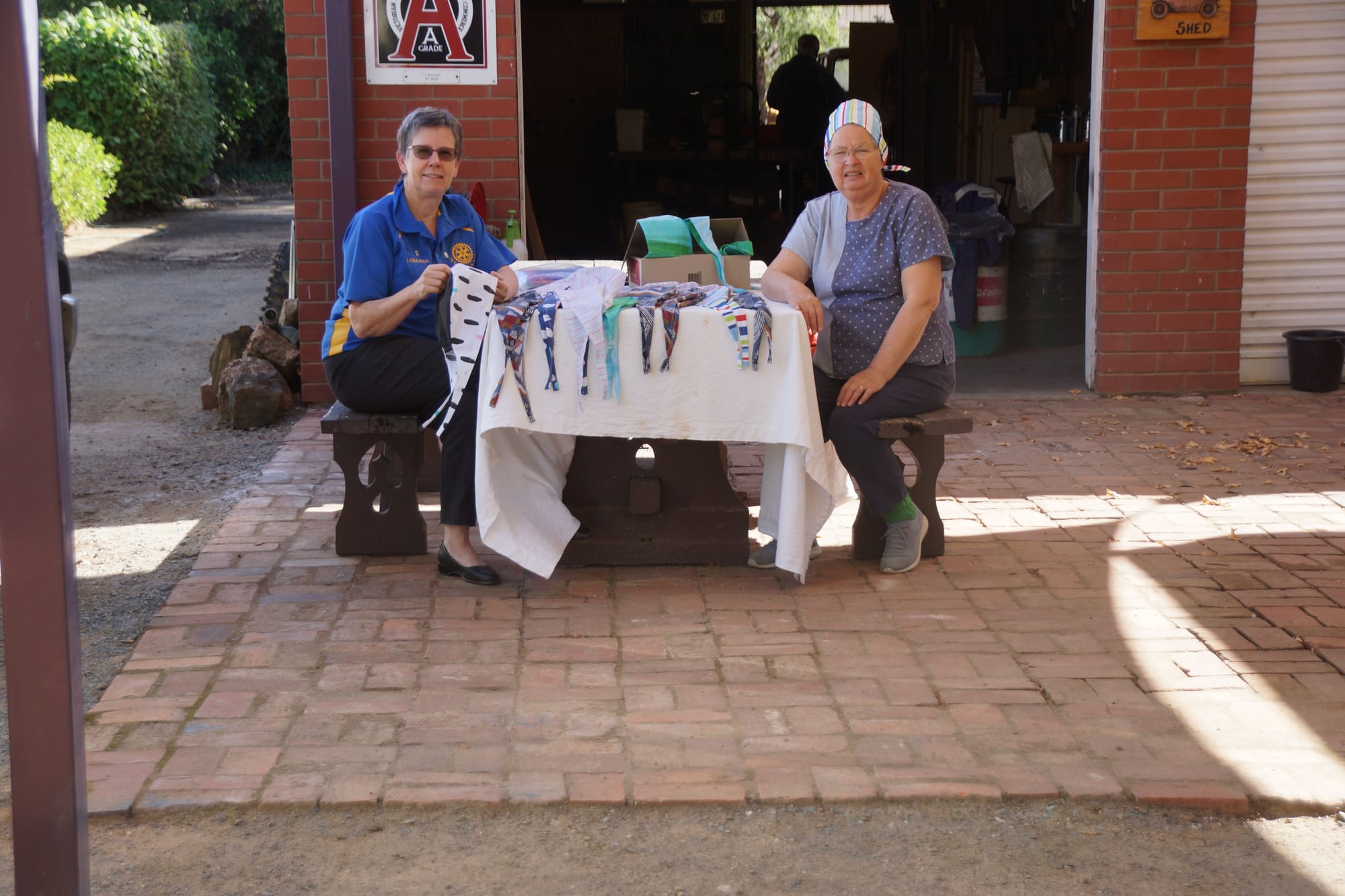 Busy protecting the carers ... Rotary Club of Numurkah president Lorraine Greenwood and fellow sewer Pam Brennan with a collection of scrub caps created in Numurkah. 