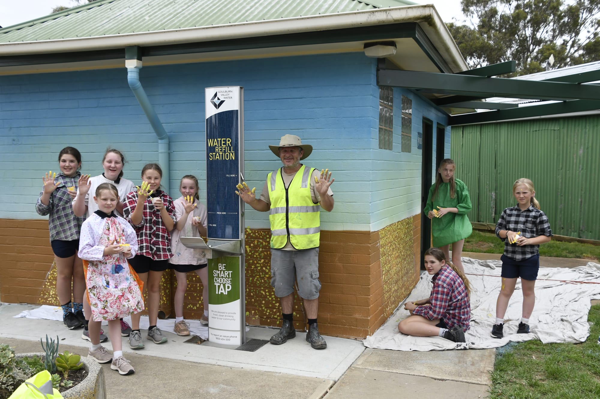 Fingers covered in paint ... Katamatite Primary School kids helped Tank from Shepparton to paint the canola fields in the town’s new mural. 
